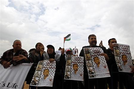 Palestinian protesters hold placards during a demonstration in support of hunger-striking Palestinian prisoner Samer al-Issawi, outside Kaplan hospital in Rehovot near Tel Aviv April 22, 2013. REUTERS/Ammar Awad